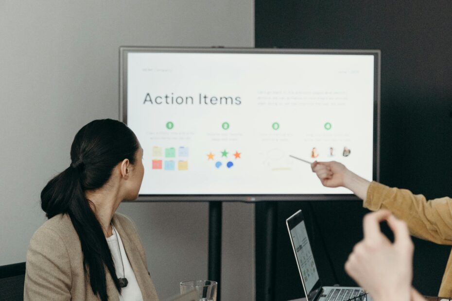 Colleagues discussing a presentation of action items in an office setting.